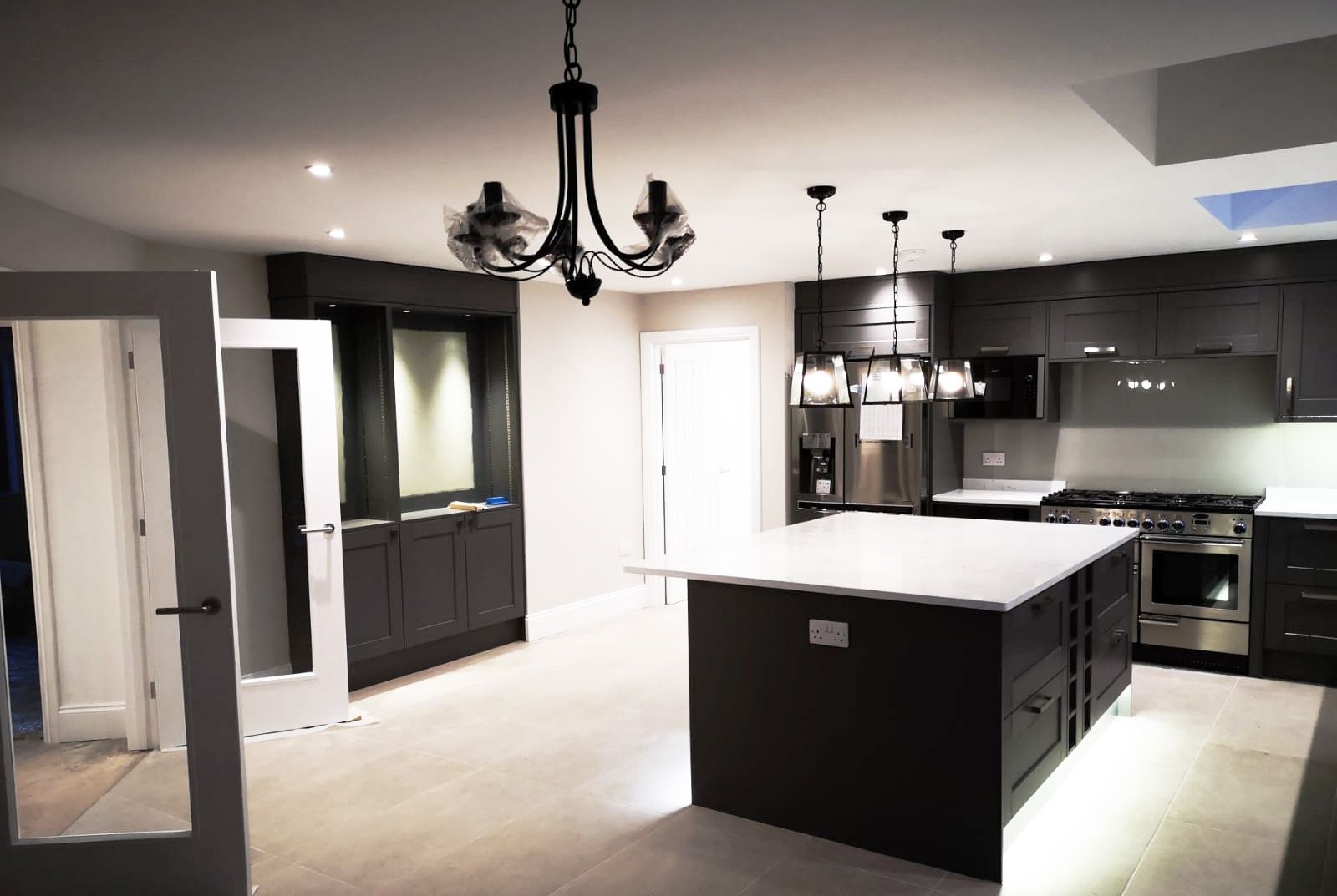 A kitchen with a large island and a chandelier hanging from the ceiling
