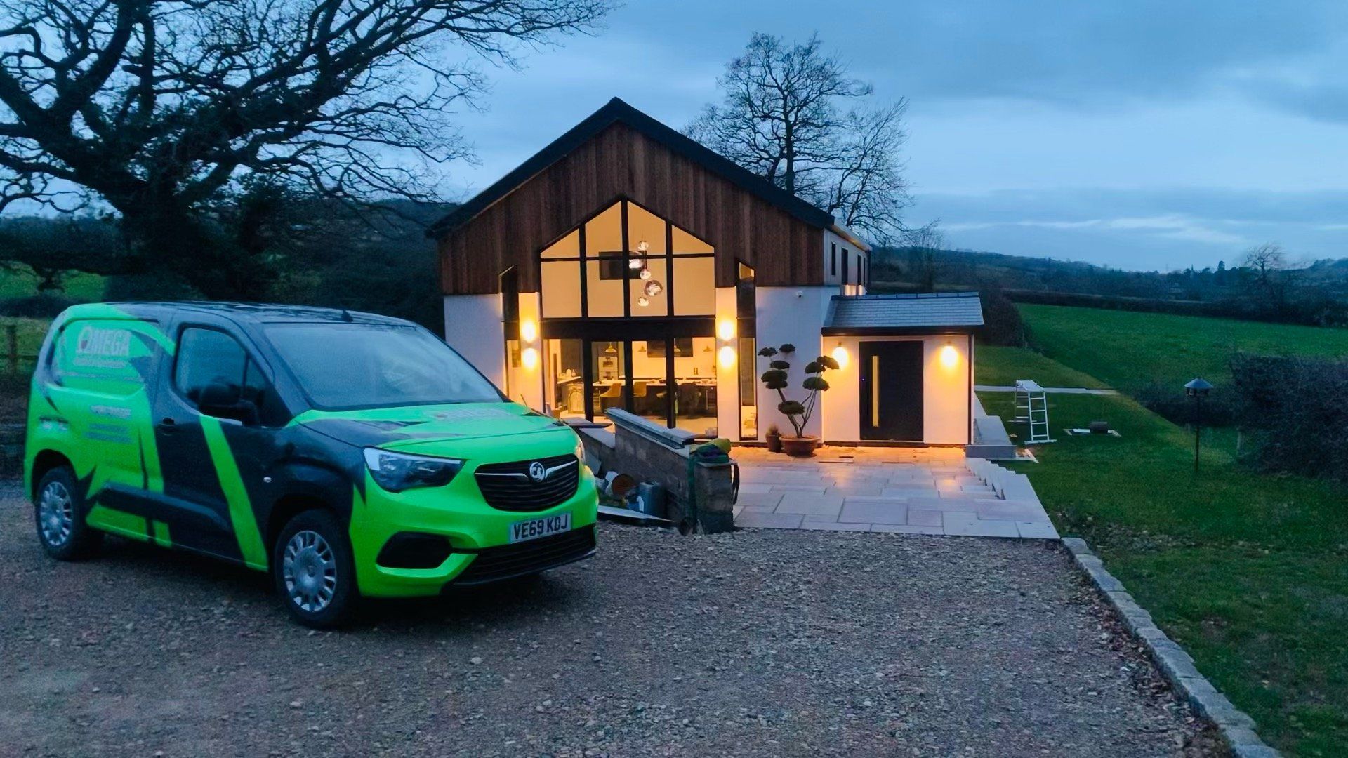 A green van is parked in front of a house