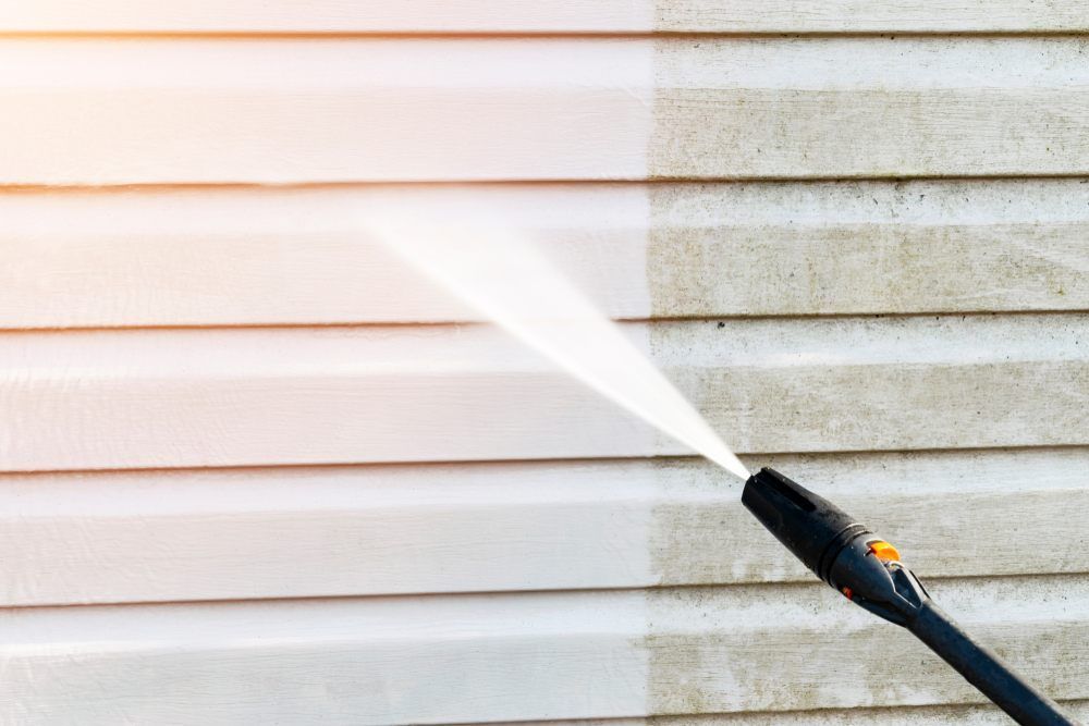 Vinyl Siding Pressure Washing? Cleaning service washing building facade with pressure water.