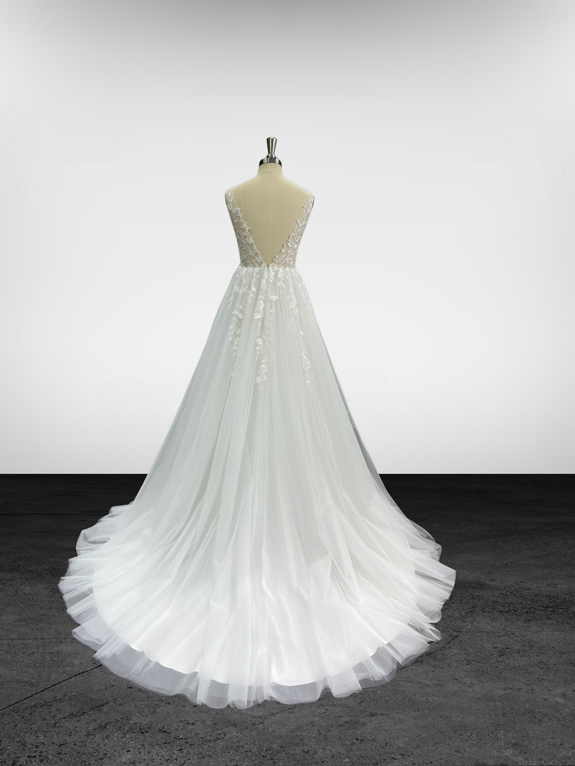 Une robe de mariée blanche est sur un mannequin dans une pièce.