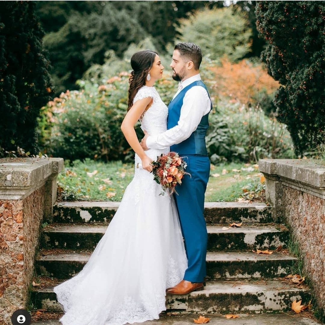 Une mariée et un marié se tiennent l'un à côté de l'autre sur un escalier.