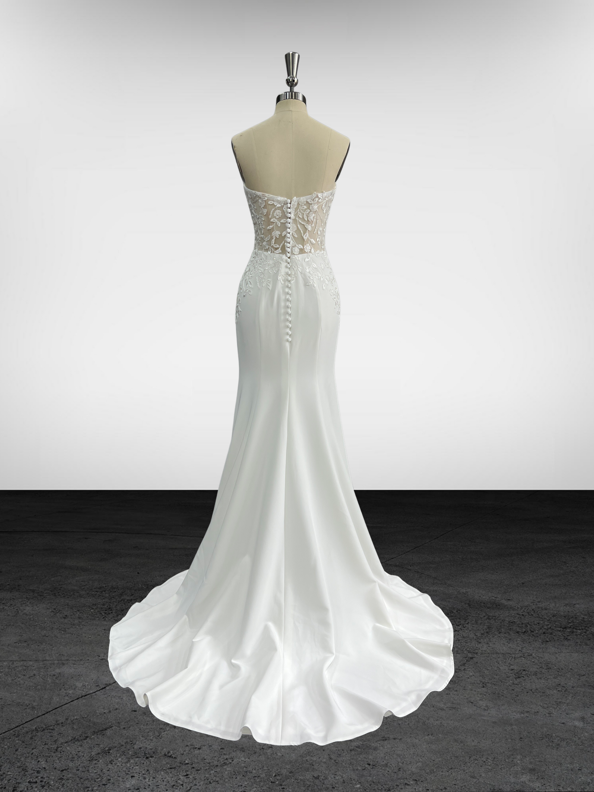 Une robe de mariée blanche est sur un mannequin dans une pièce