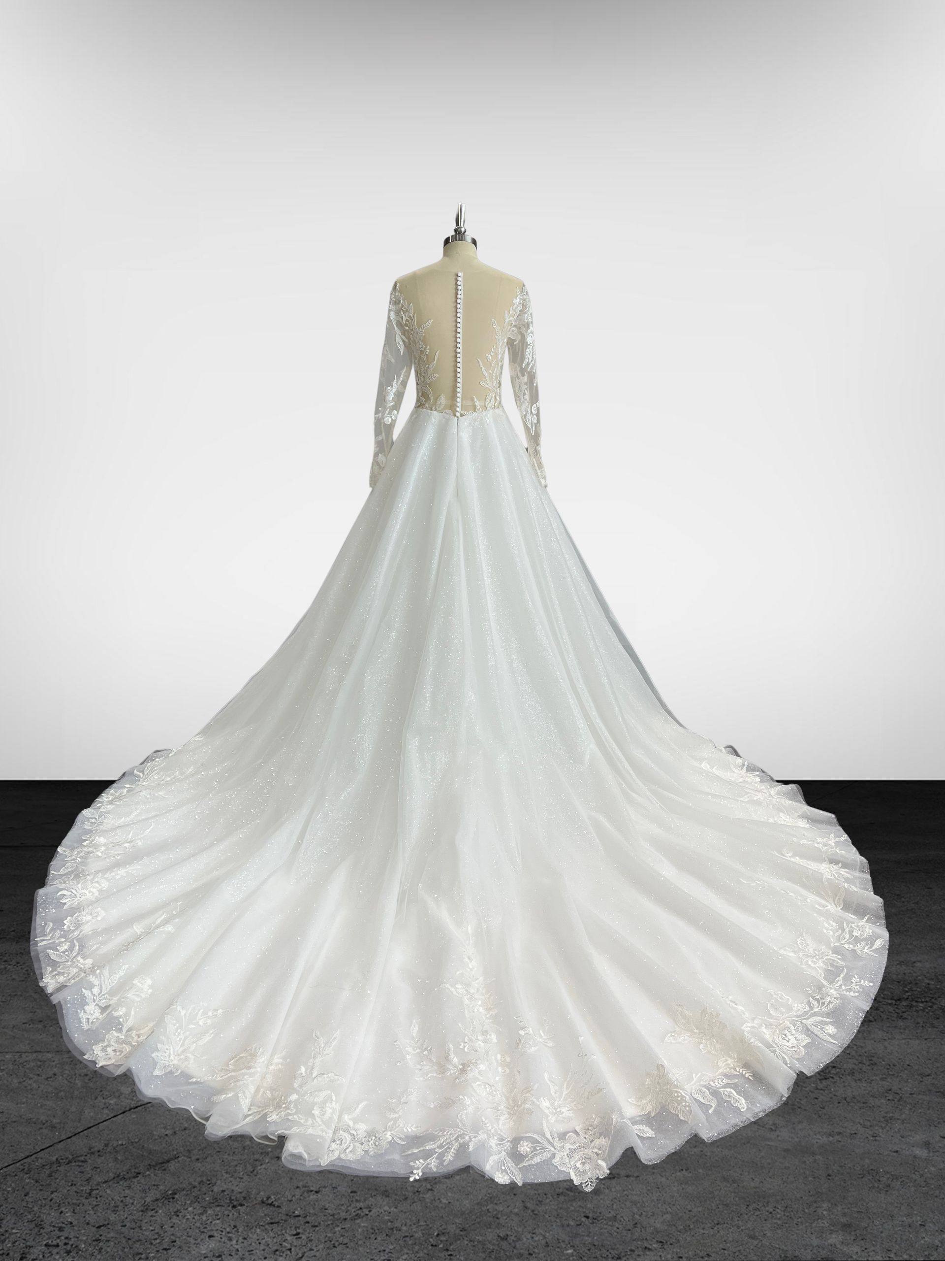 Une robe de mariée blanche à manches longues est sur un mannequin.