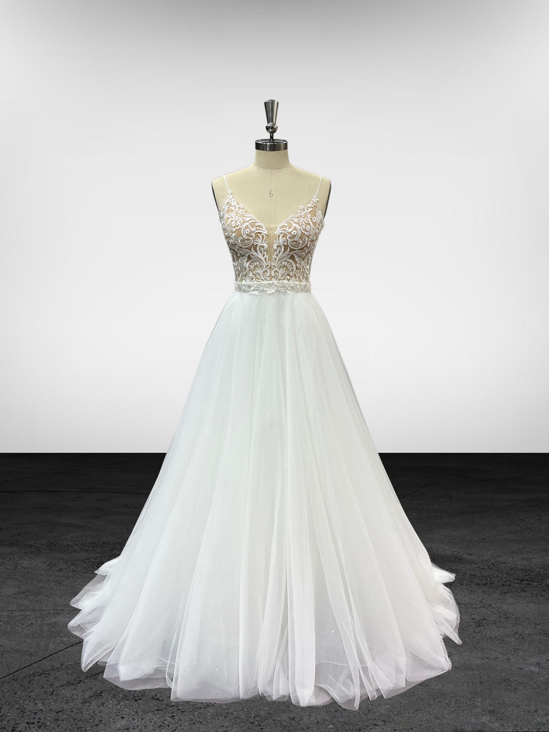 Une robe blanche est sur un mannequin dans une pièce.