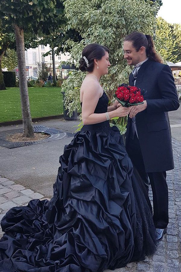La mariée porte une robe noire et le marié porte un smoking noir.