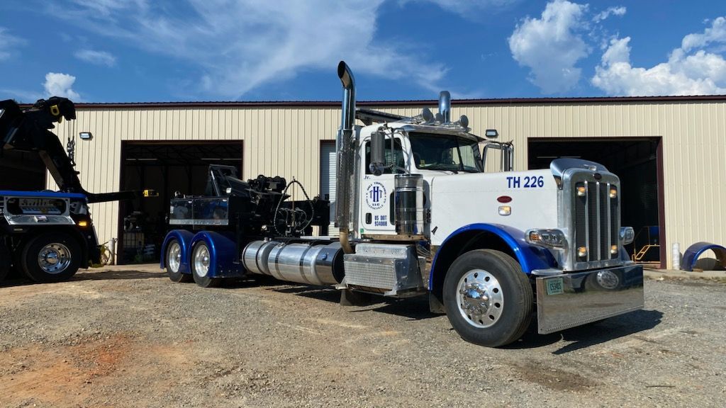 A white and blue semi truck is parked in front of a building.