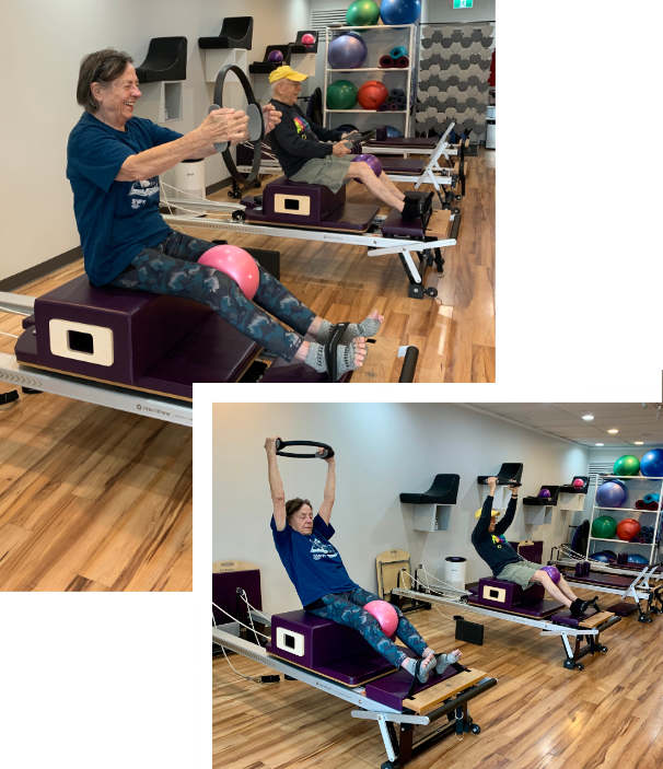 A woman is sitting on a pilates machine in a gym.