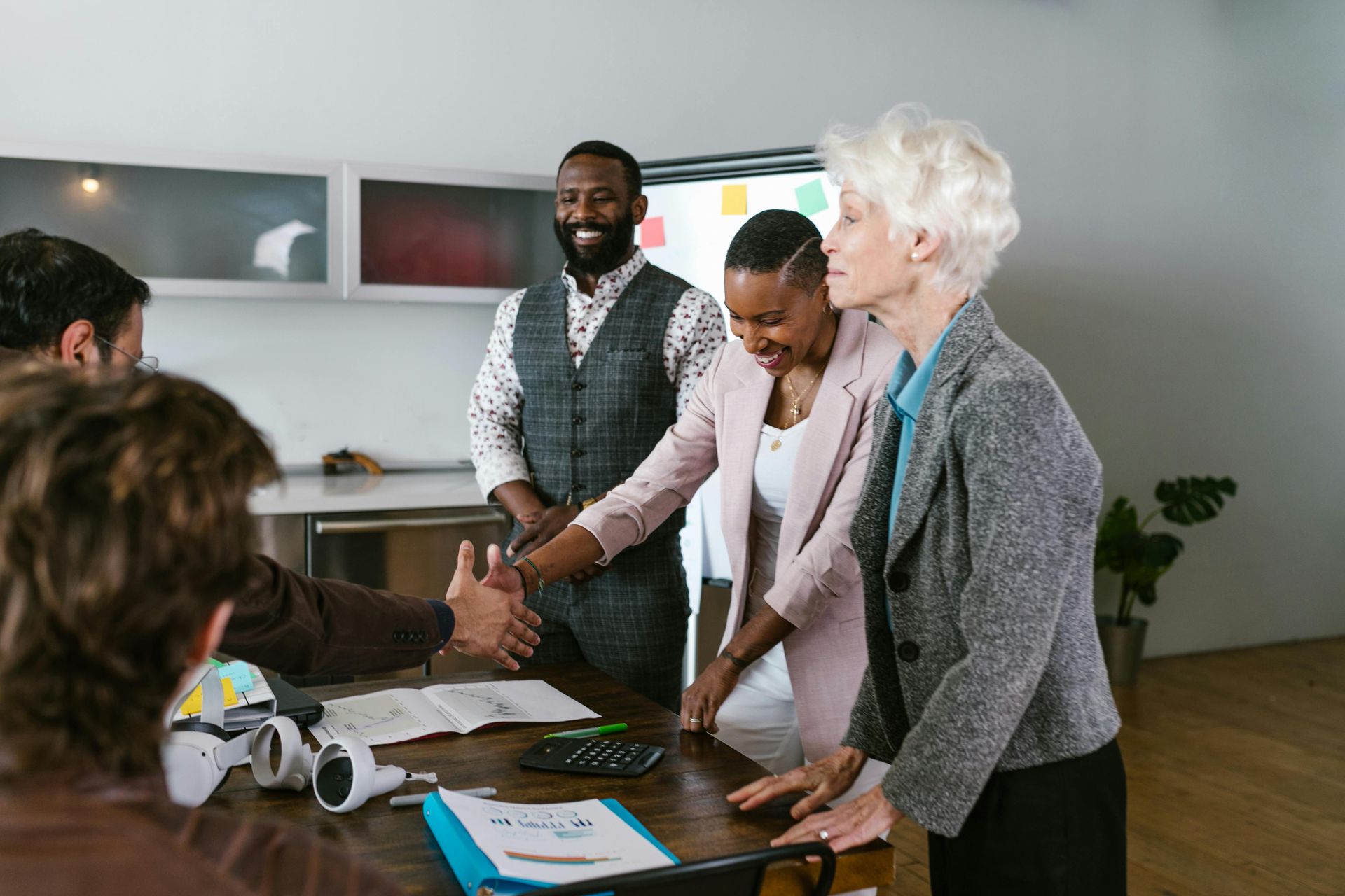 A group of people are shaking hands in an office.