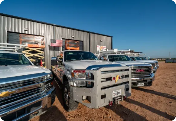 A row of trucks are parked in front of a building.