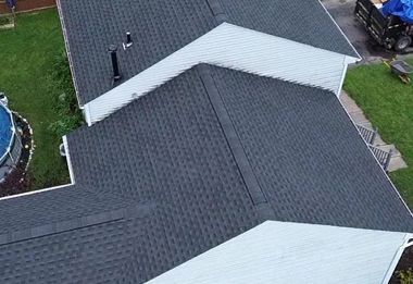 A group of people are working on the roof of a house