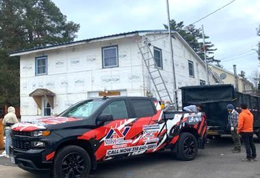 A truck is parked in front of a house under construction.