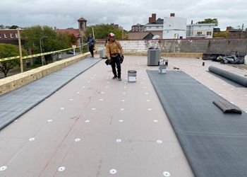 A man is standing on the roof of a building.