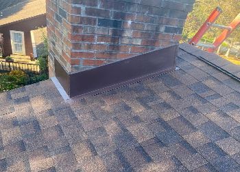 A chimney is sitting on top of a roof next to a ladder.