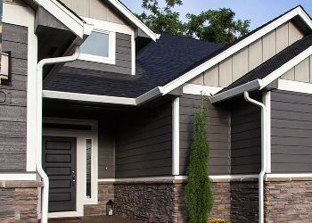 The front of a house with a black door and a blue roof.