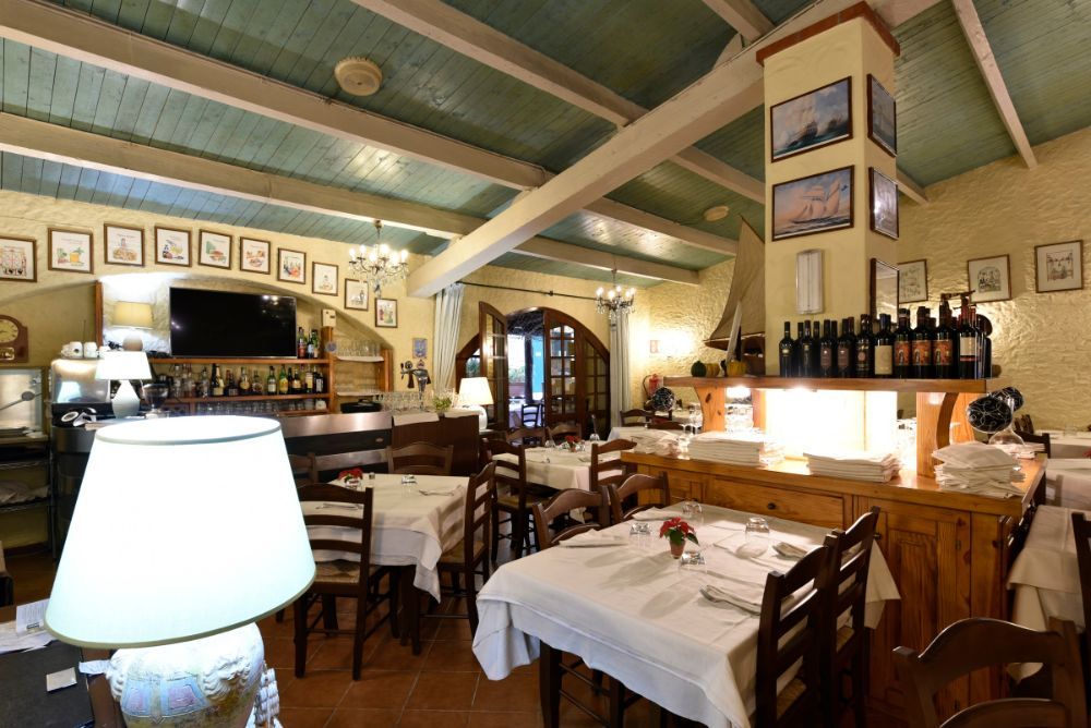 ristorante con soffitto a travi e arredi rustici