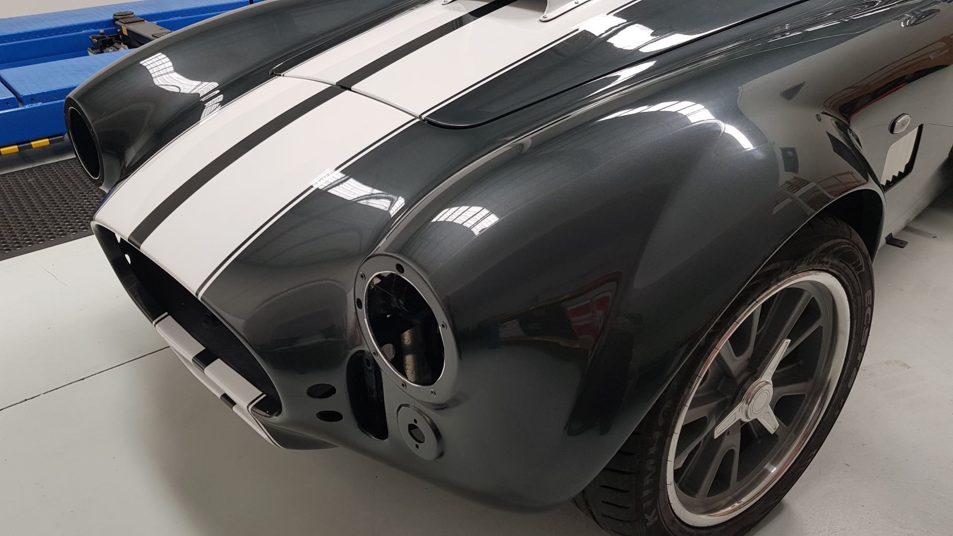 close-up of the front left quarter panel of a dark gray AC Cobra