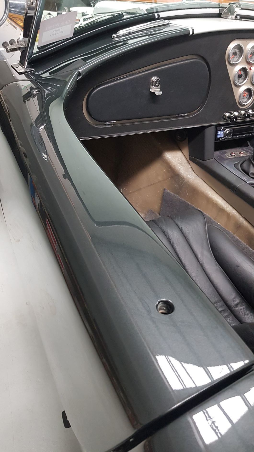 image shows the interior of a 1963 Shelby Cobra, specifically the passenger side