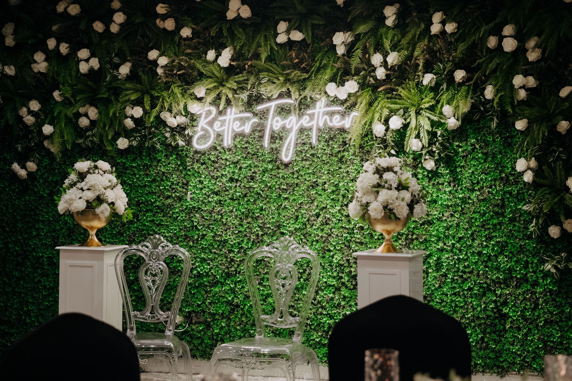 Çiçeklerle dolu yeşil bir duvar ve üzerinde ``birlikte daha iyiyiz'' yazan neon bir tabela. | Aldino Hotel 