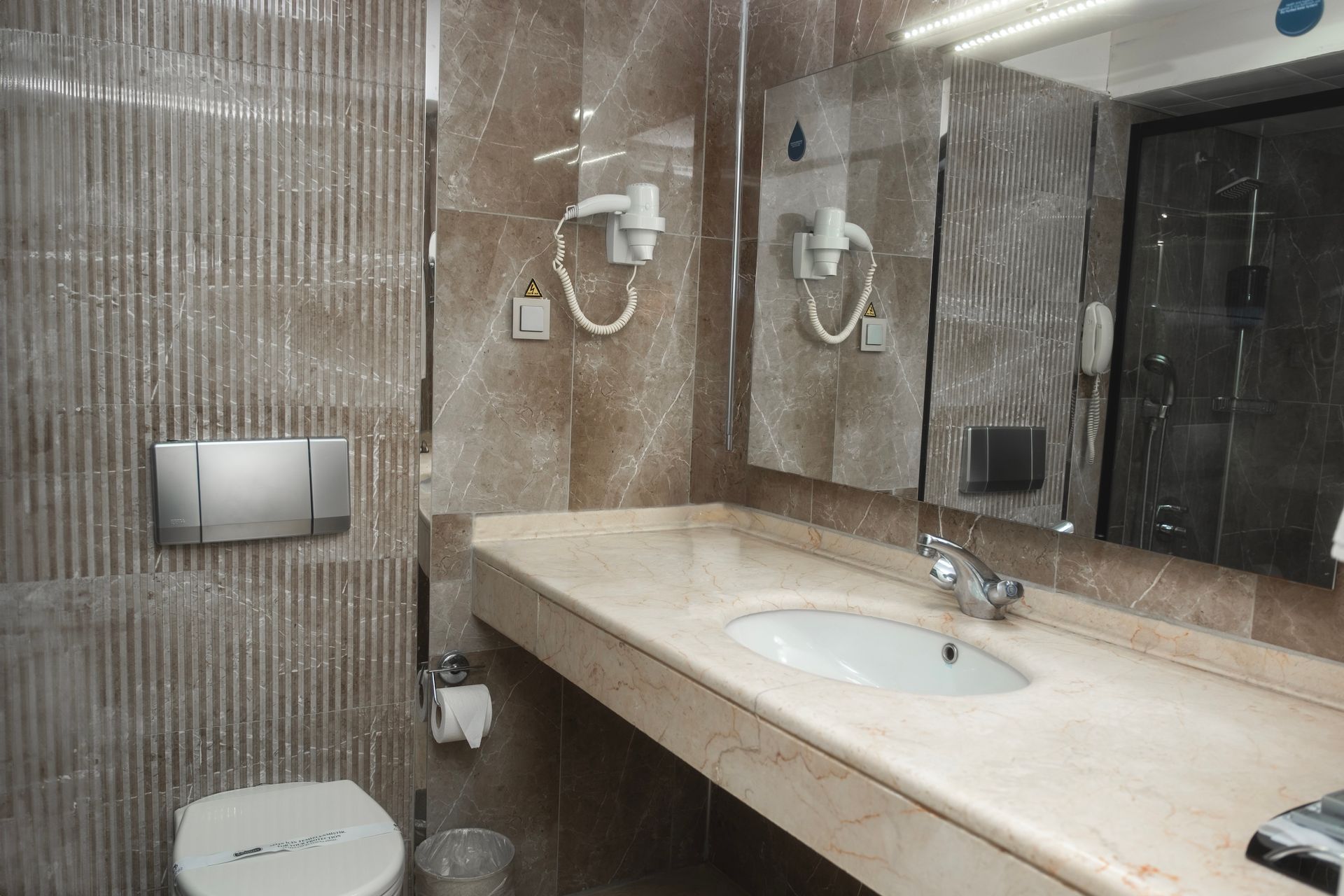 A bathroom with a sink , toilet and mirror. | Aldino Hotel 
