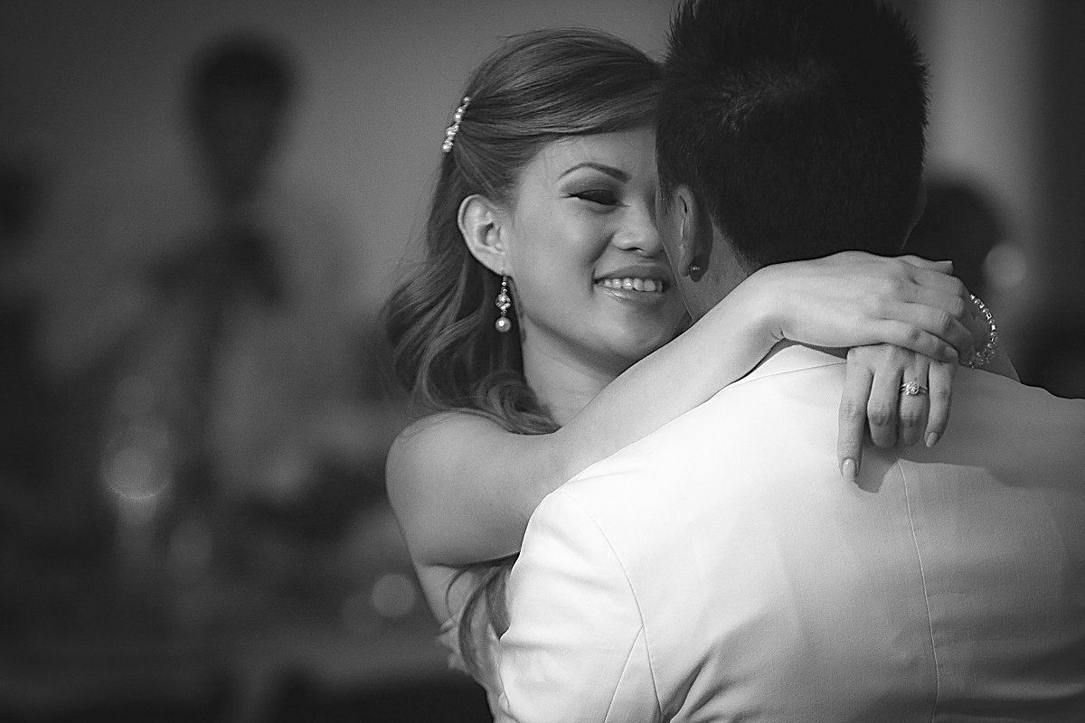 A black and white photo of a bride and groom dancing.