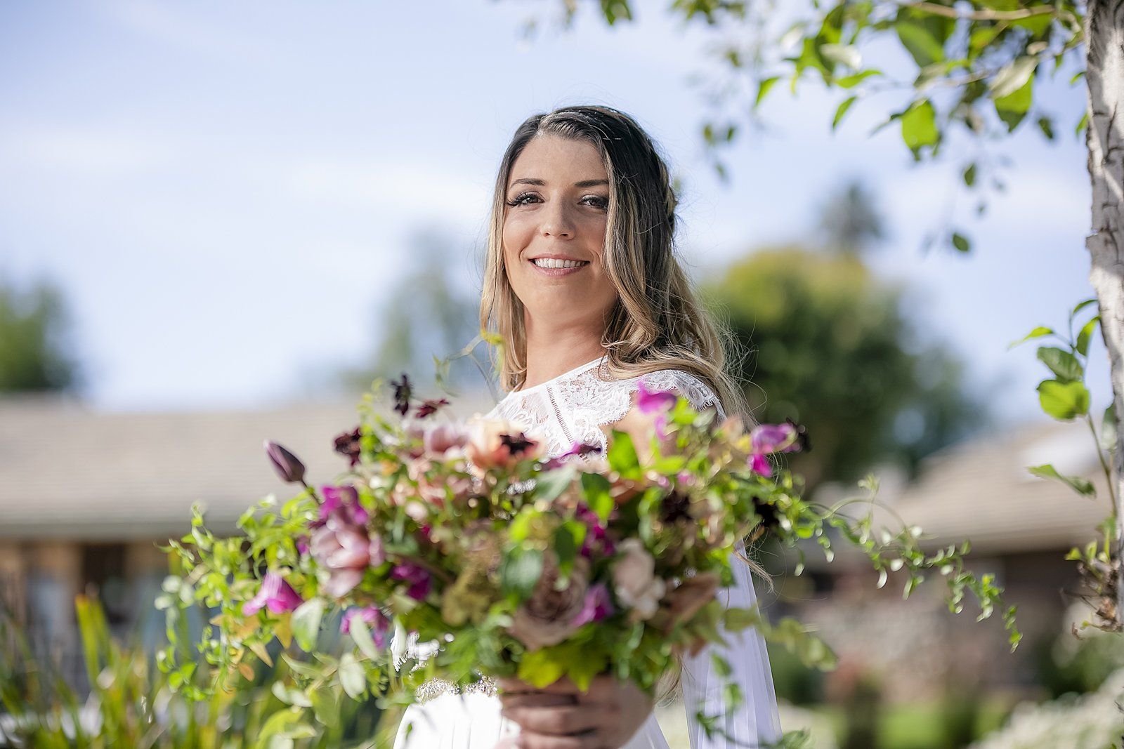 A woman in a white dress is holding a bouquet of flowers.