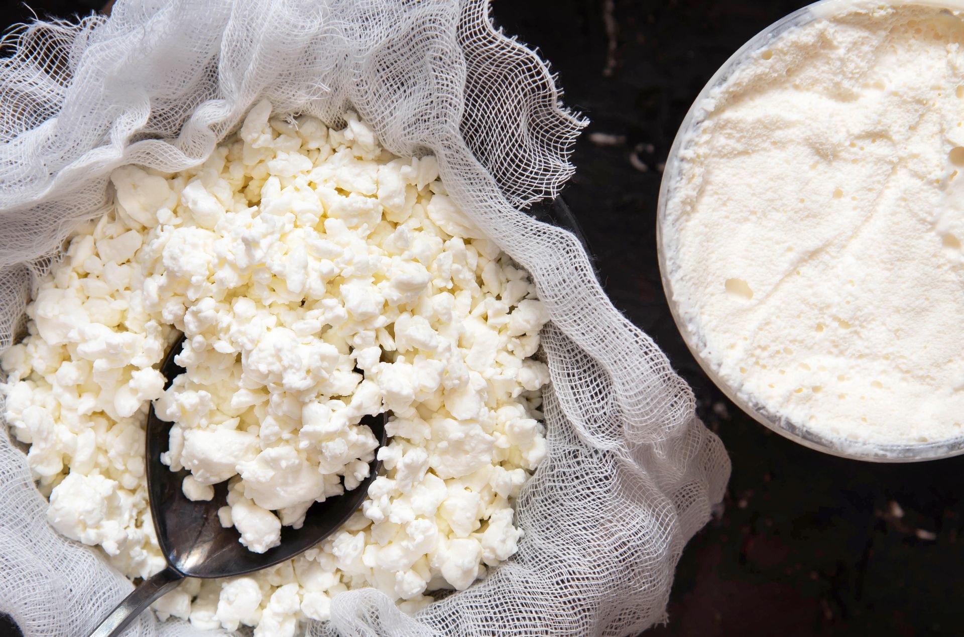 A bag of cottage cheese with a spoon in it next to a bowl of cottage cheese.