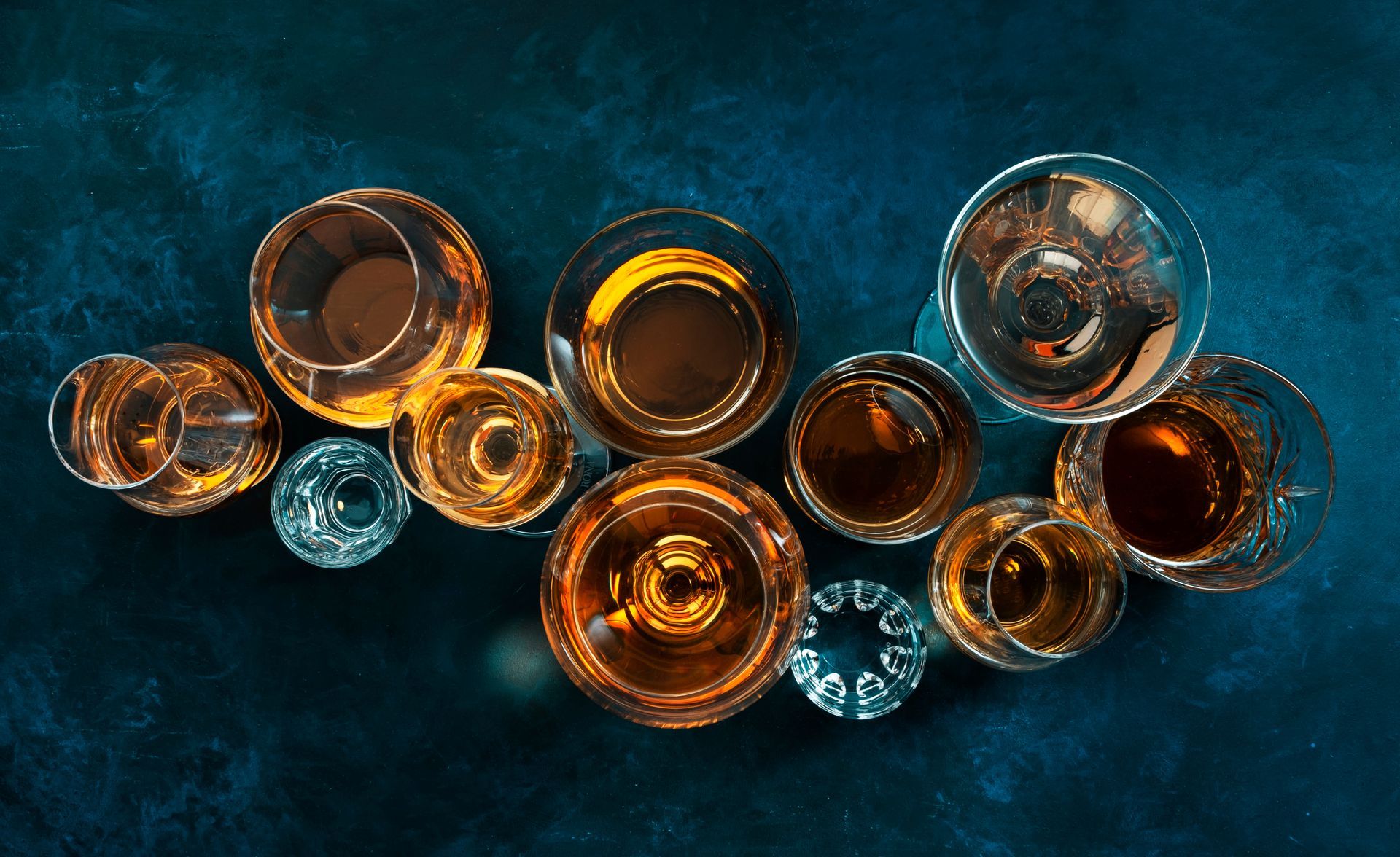 A group of shot glasses filled with different types of alcohol on a table.