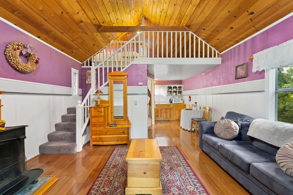 A living room with a couch and stairs leading to the second floor.