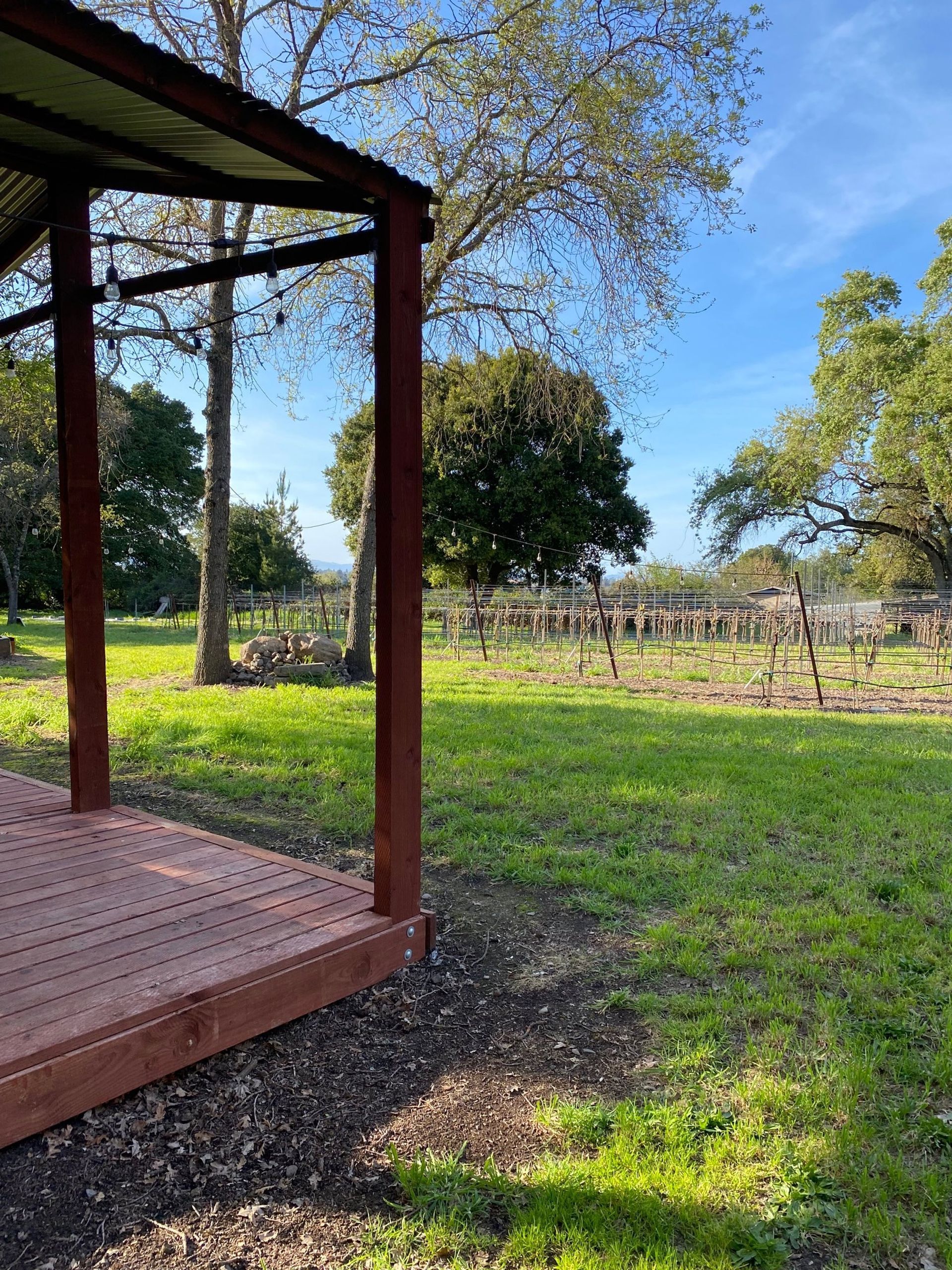 A wooden deck is sitting in the middle of a grassy field.