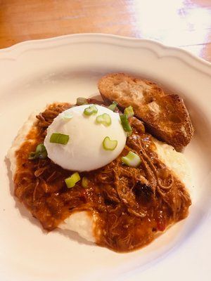 A close up of a plate of food with a poached egg on top.