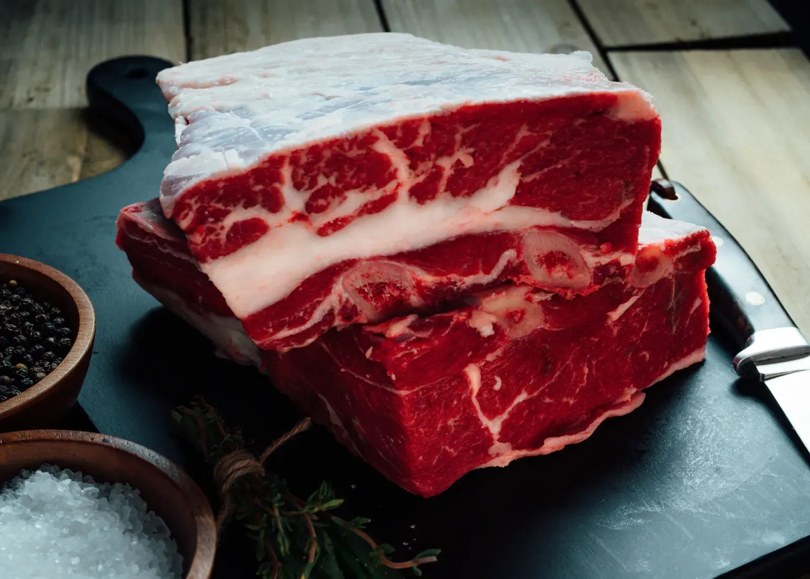 Raw ranch-raised steak photographed on butcher board, highlighting texture and quality.