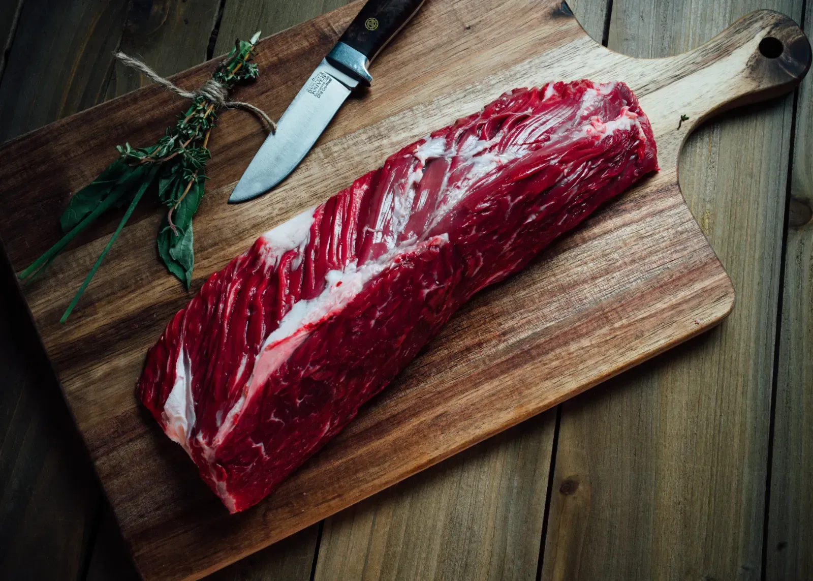 Fresh ranch beef displayed on wooden cutting board.
