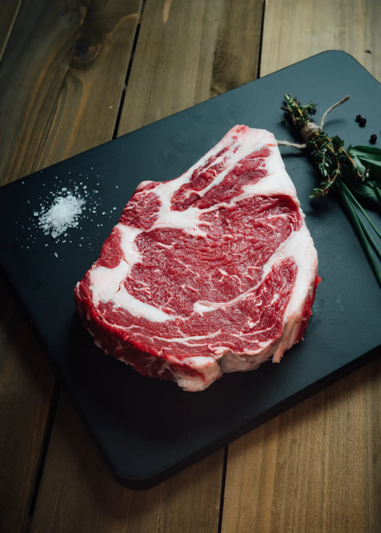 Marbled Angus beef cut prepared on wooden tray.