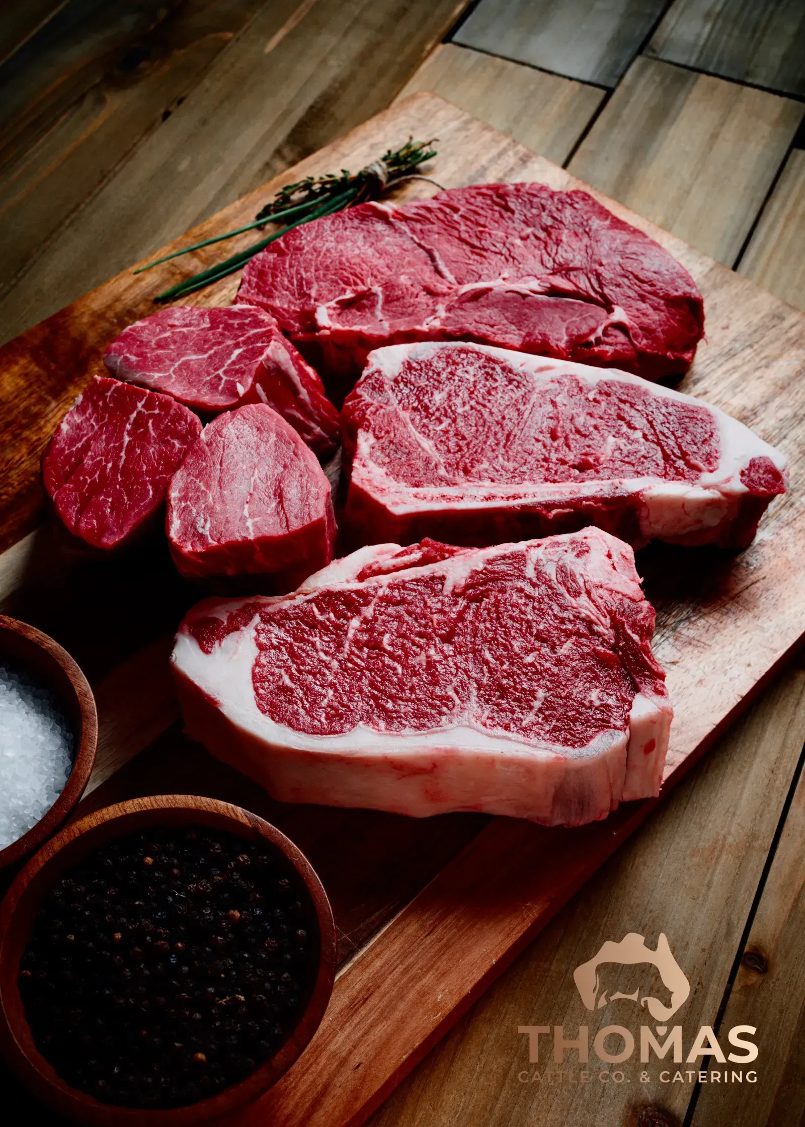 Farm-to-table beef cut on display board with herbs and salt.