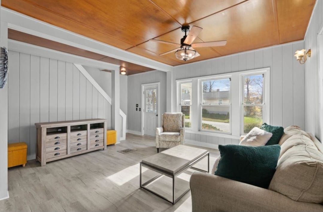 Living room with wood ceiling, light gray walls, white trim, and a beige sofa.
