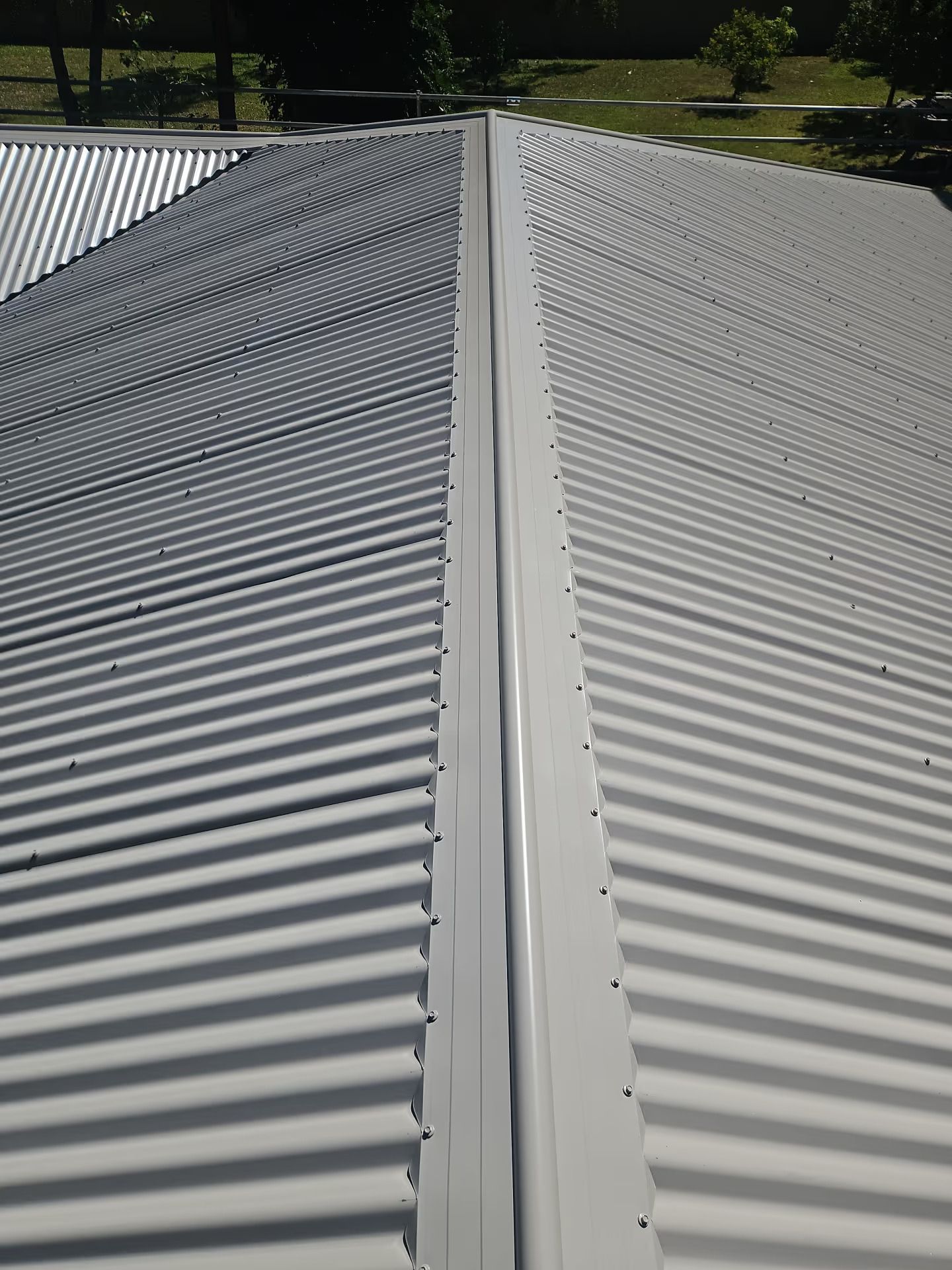 White Corrugated Metal Roof With a Central Seam — Over the Top Roofing Specialists in Kunda Park, QLD