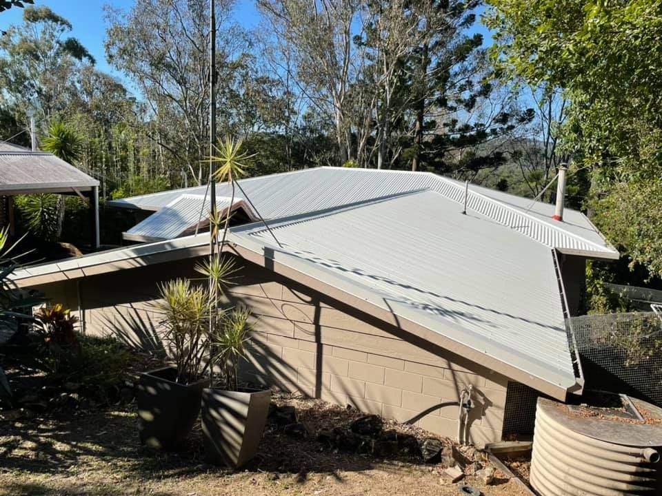 House With a Light Gray Metal Roof, Surrounded by Trees — Over the Top Roofing Specialists in Deception Bay, QLD