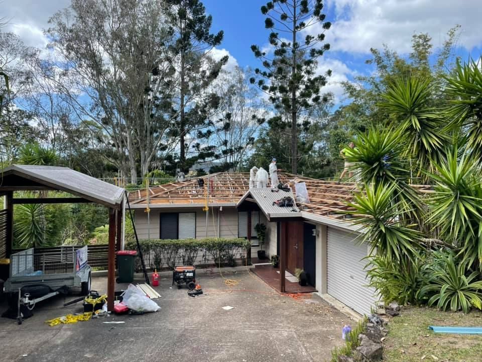 Roofers in Protective Suits Working on a House Roof on a Sunny Day — Over the Top Roofing Specialists in Buderim, QLD