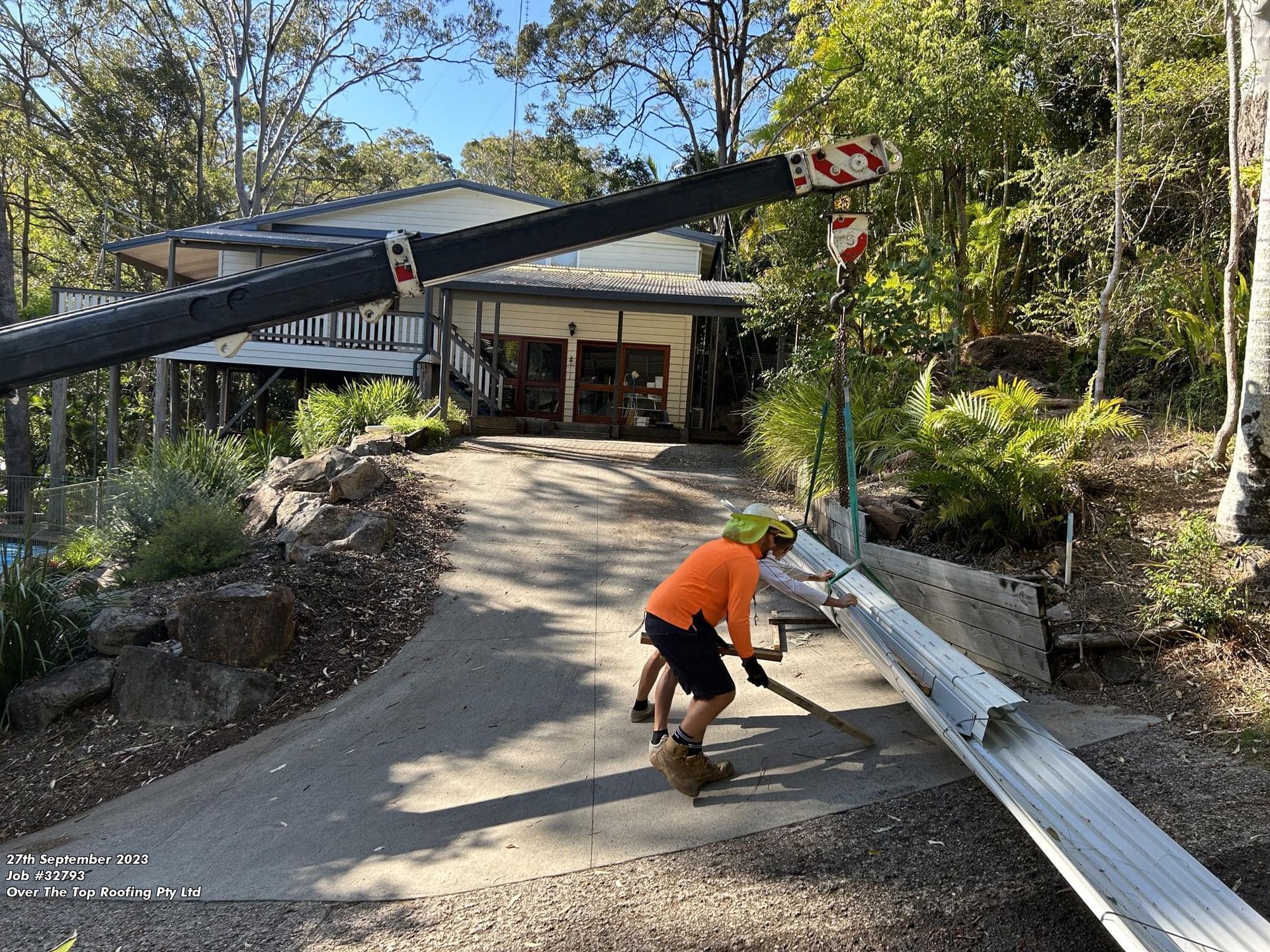 Construction Workers With a Crane Lift Metal Beams on a Driveway — Over the Top Roofing Specialists in Nambour, QLD