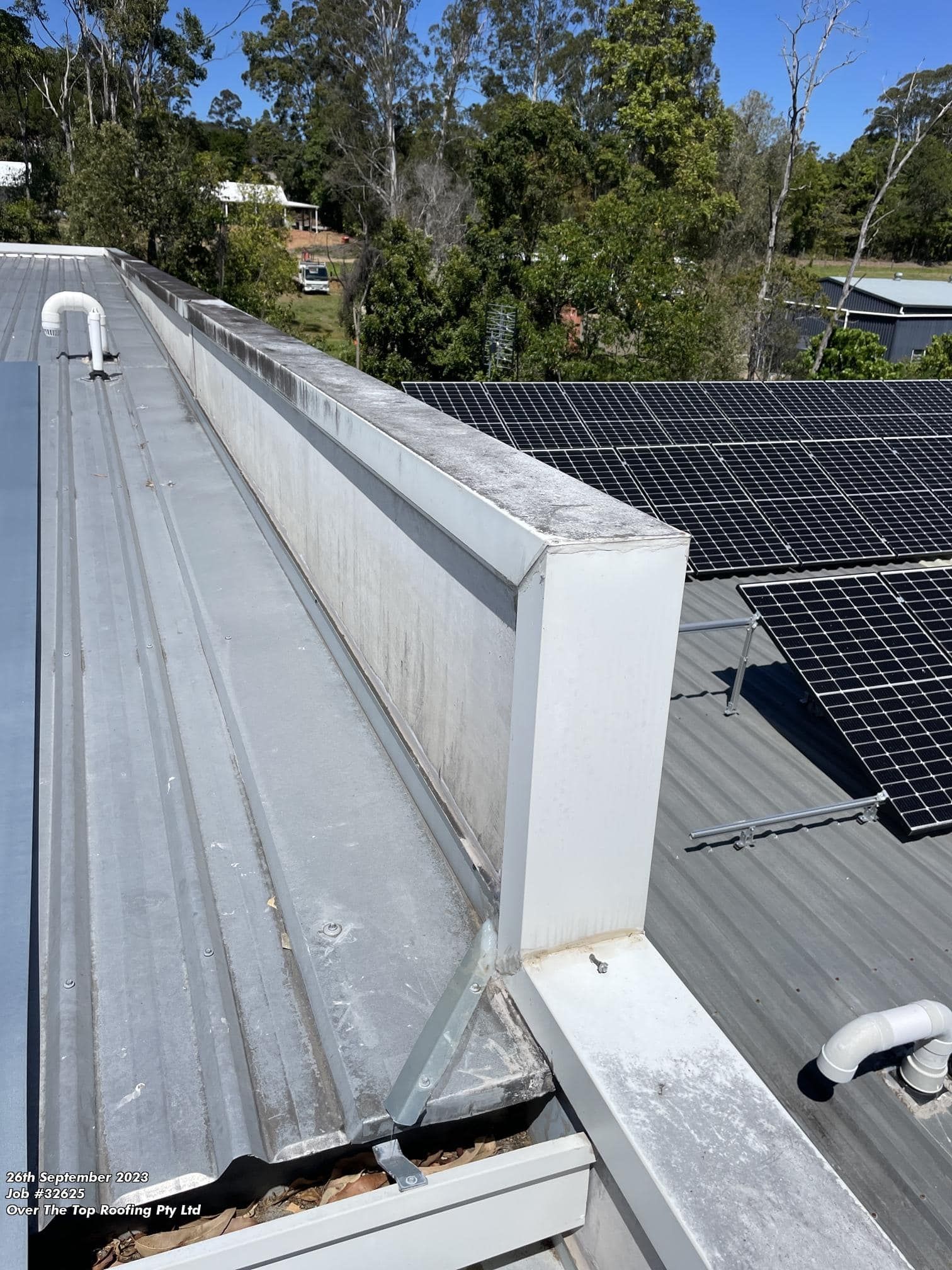 A Metal Roof With Solar Panels and a Rectangular Gutter, Outdoors — Over the Top Roofing Specialists in Gympie, QLD
