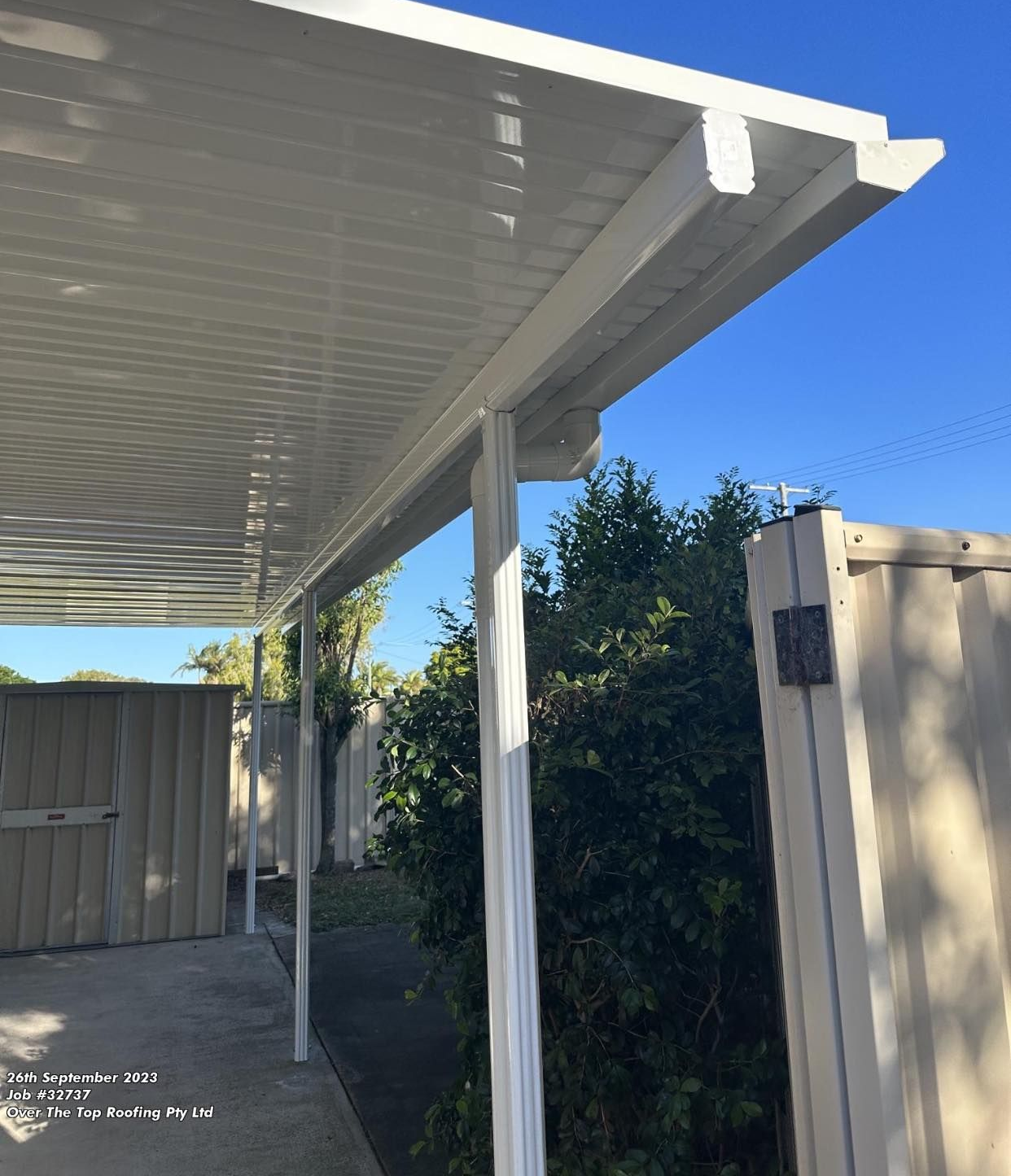 White Patio Roof With Supporting Posts, Against Blue Sky and Fence — Over the Top Roofing Specialists in Buderim, QLD