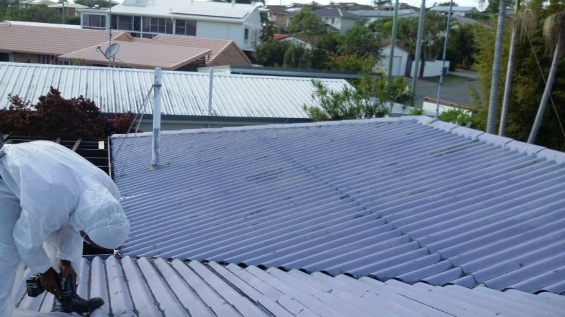 Person in Protective Suit Working on a Corrugated Metal Roof — Over the Top Roofing Specialists in Gympie, QLD