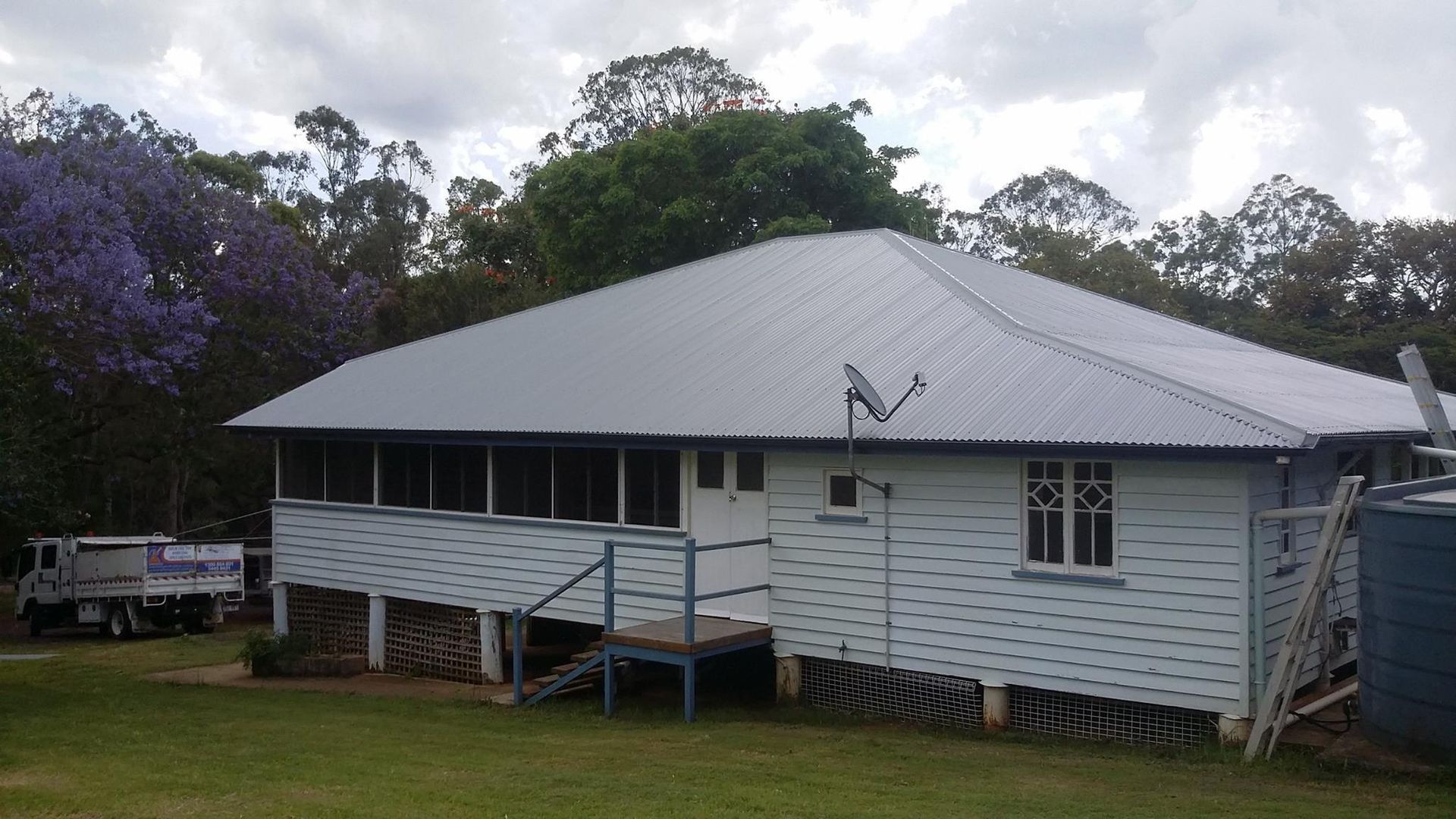 Light Blue House With a Corrugated Metal Roof — Over the Top Roofing Specialists in North Lakes, QLD