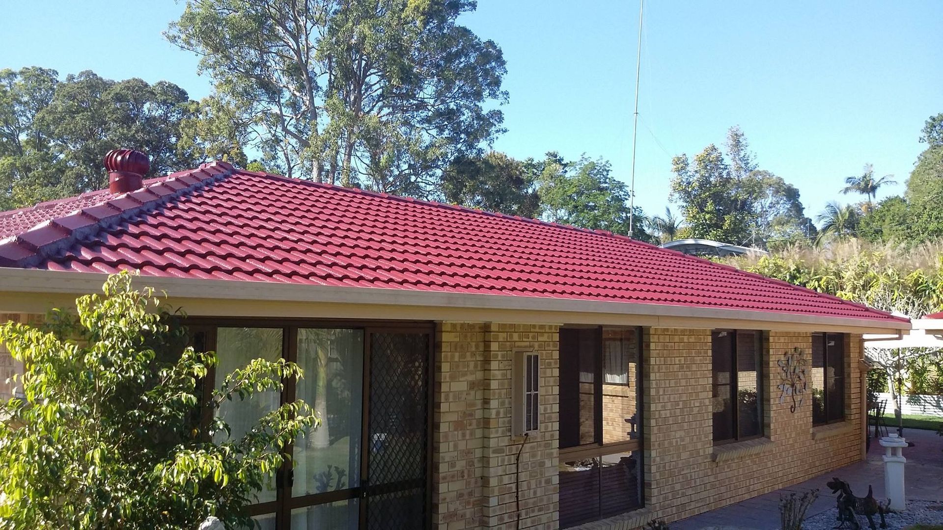 Red Tiled Roof on a Single-story Brick House With Windows — Over the Top Roofing Specialists in Gympie, QLD