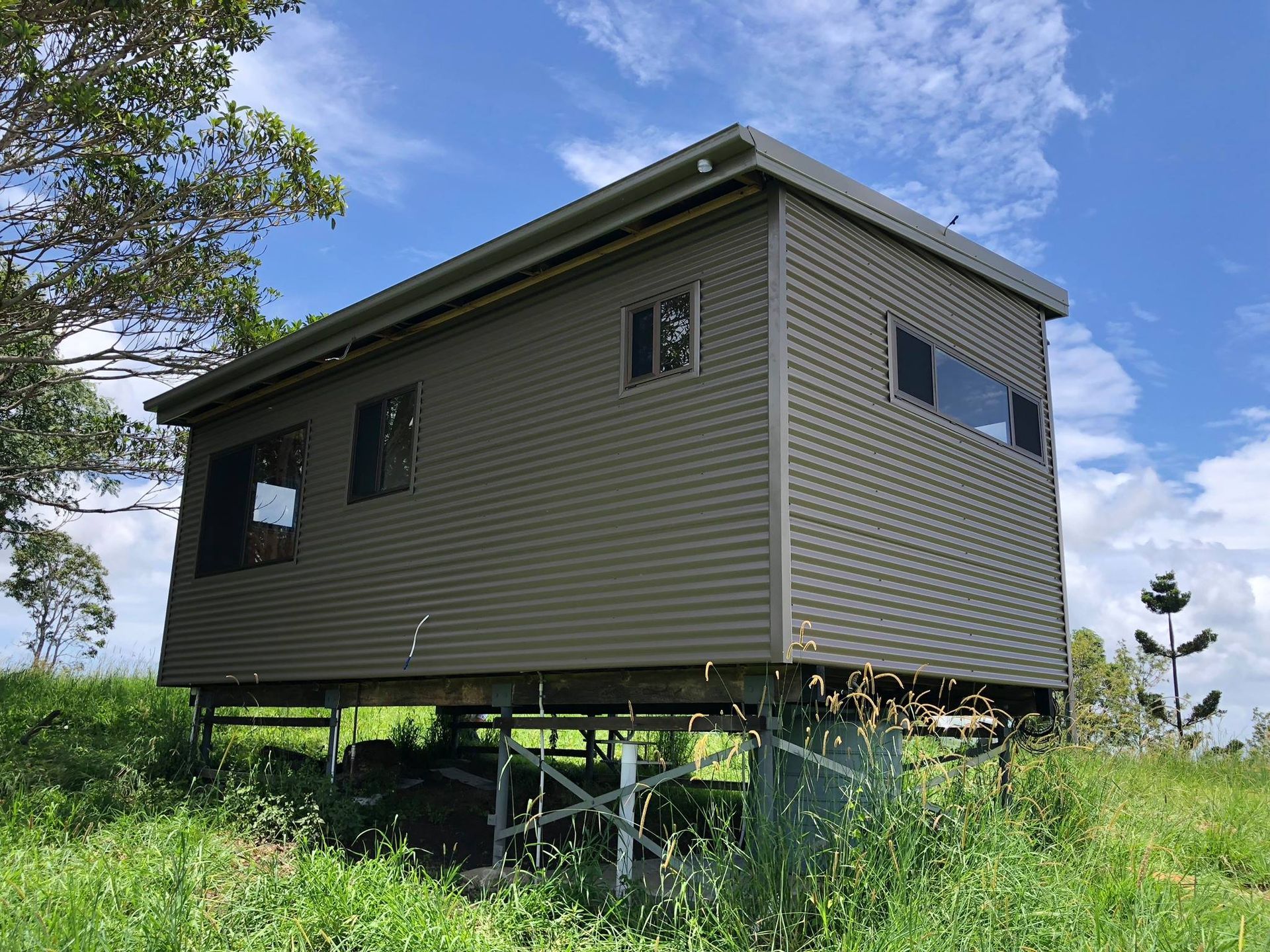 A Small, Elevated Corrugated Metal Building — Over the Top Roofing Specialists in Caboolture, QLD