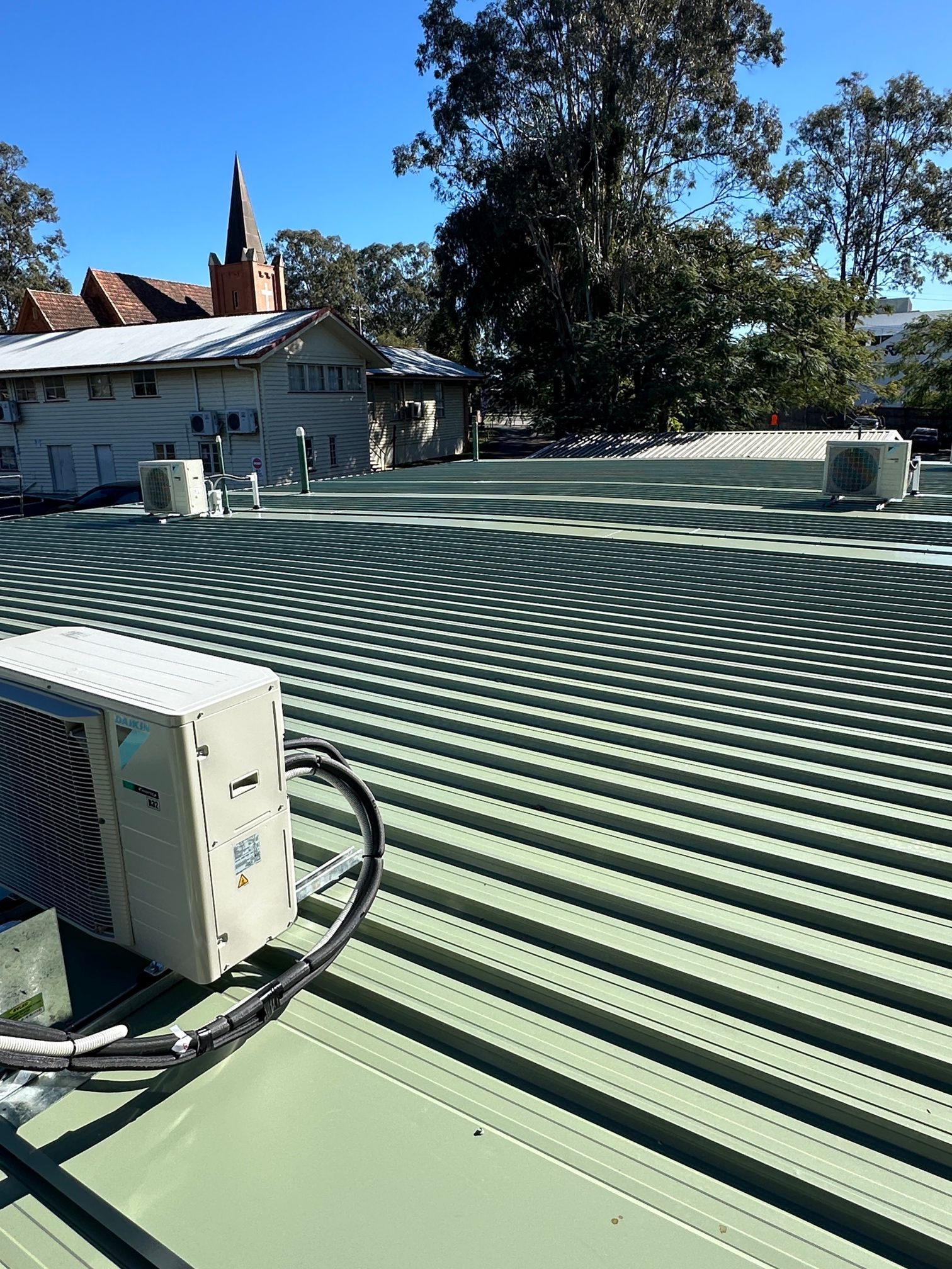 Green Corrugated Metal Roof With Air Conditioning Units — Over the Top Roofing Specialists in Kunda Park, QLD