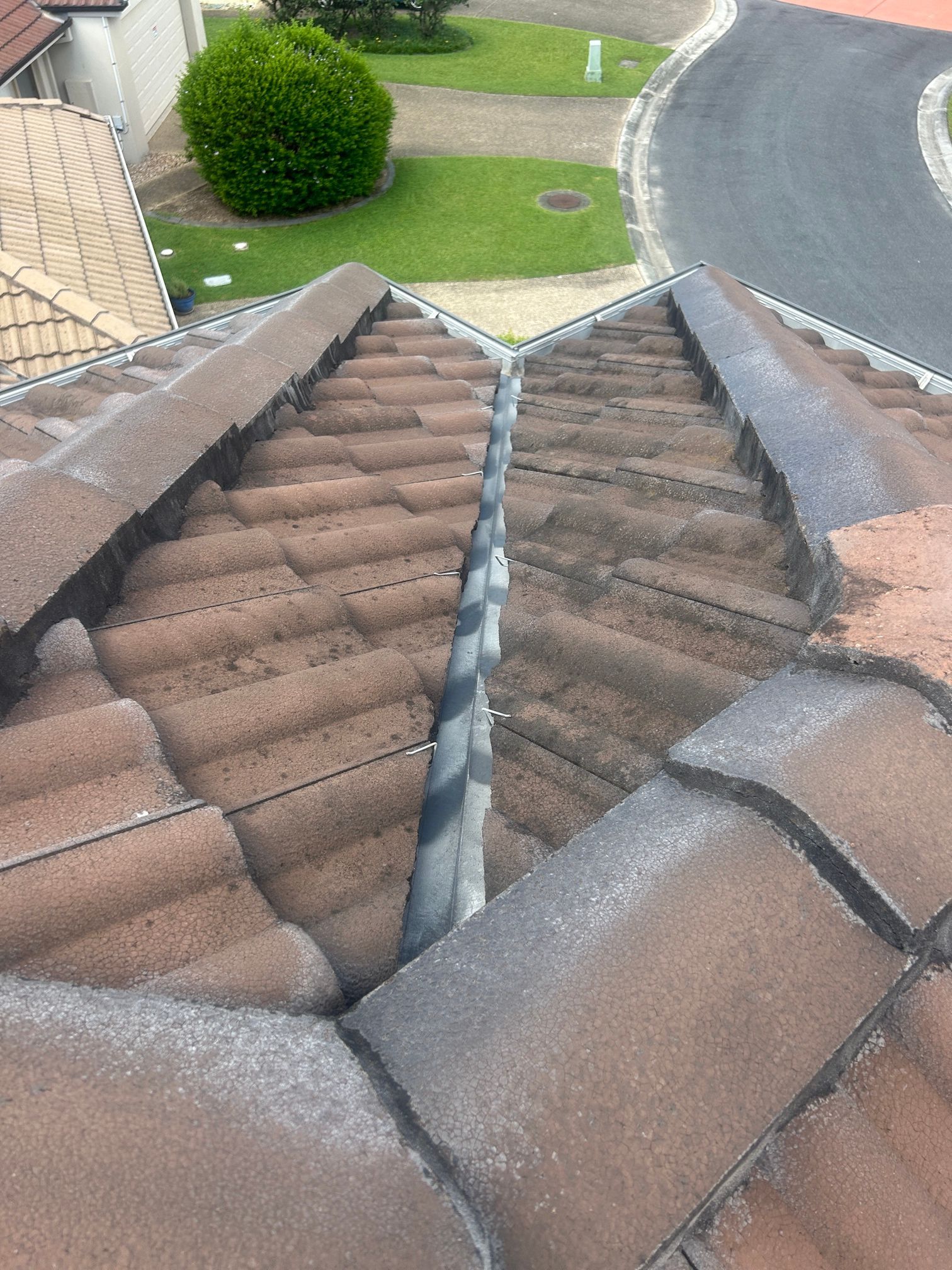 View of a Tiled Roof Valley With a Dark Metal Flashing — Over the Top Roofing Specialists in Kunda Park, QLD