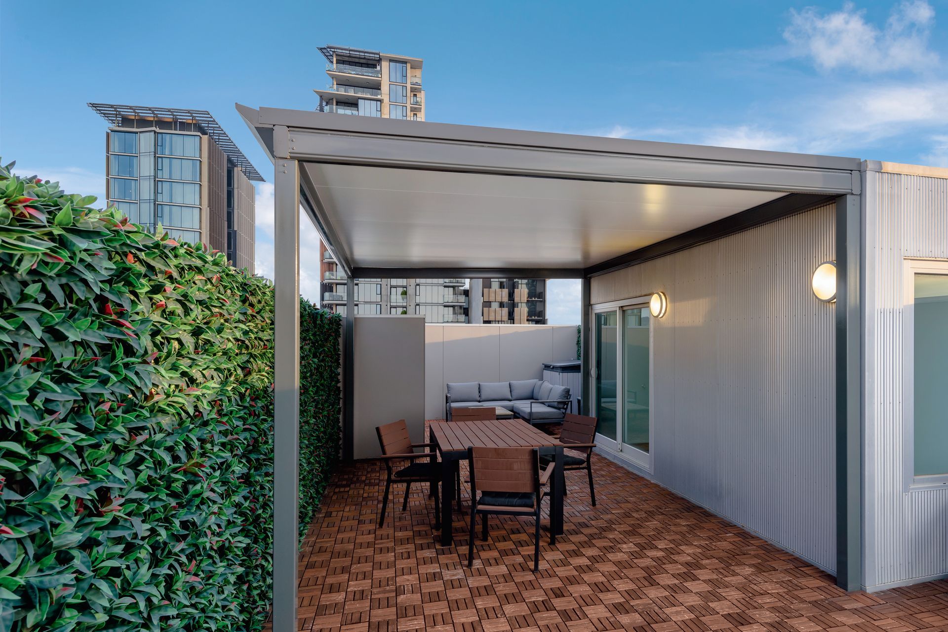 Patio With Table, Chairs, Sofa, and Leafy Hedge — Over the Top Roofing Specialists in Kunda Park, QLD