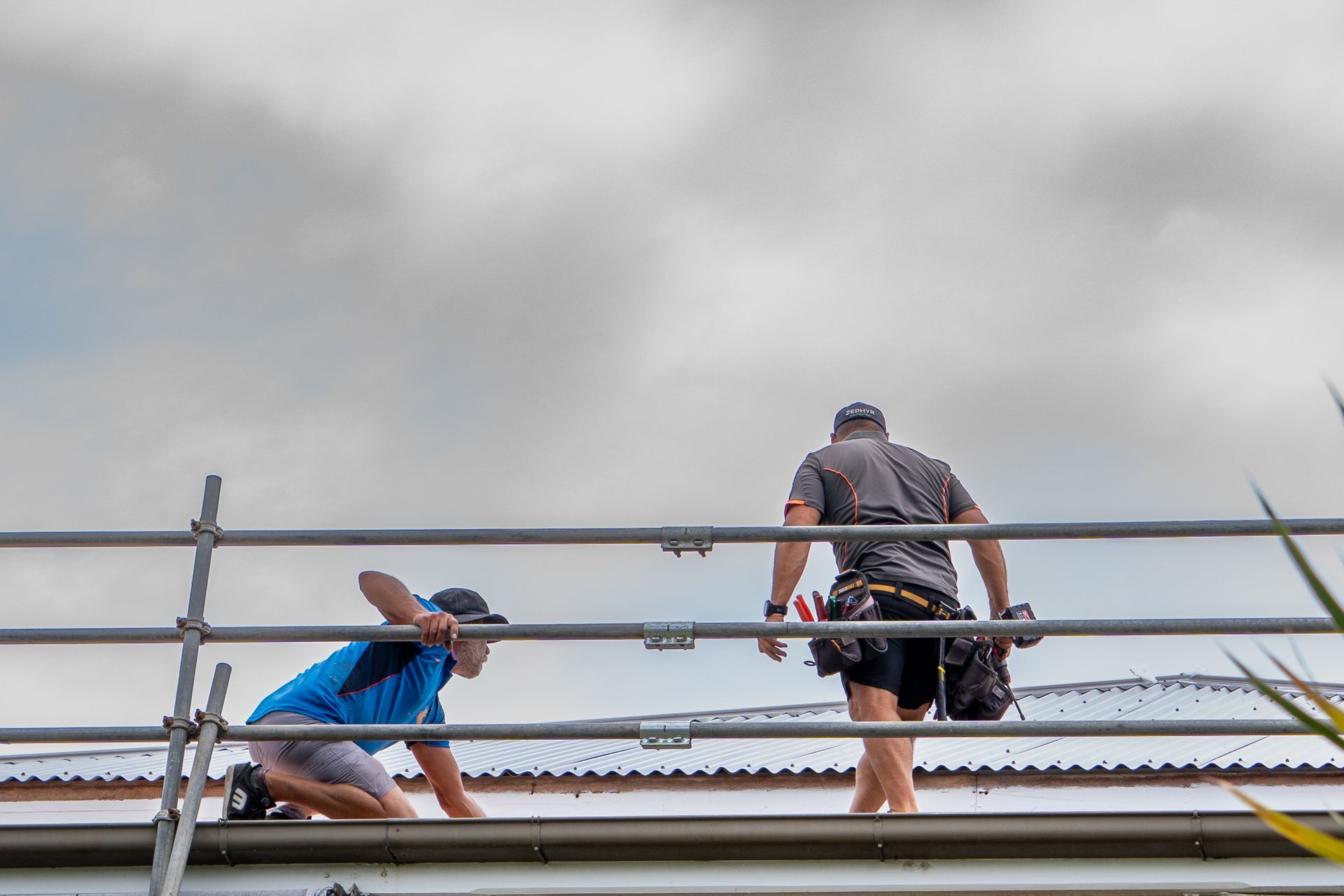 Two Workers on Scaffolding Inspecting a Rooftop — Over the Top Roofing Specialists in Kunda Park, QLD