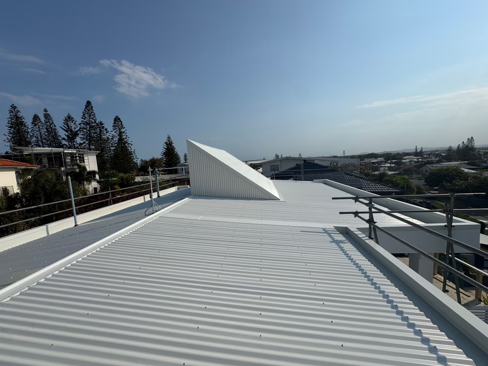 White Corrugated Metal Roof With a Triangular Structure — Over the Top Roofing Specialists in Kunda Park, QLD